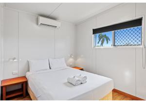 麦凯Discovery Parks - Mackay的白色卧室配有带2条毛巾的床