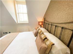 浦耳Quayside Quarters的一间卧室配有一张带白色床单的床和一扇窗户。