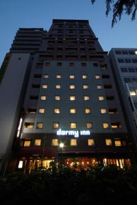 广岛多美迎广岛酒店的一座高大的建筑,旁边有一个标志