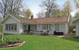 BorNice home in Bor with 2 Bedrooms, Sauna and WiFi的一座白色的小房子,在庭院里设有一个庭院