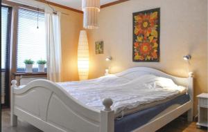 维默比2 Bedroom Amazing Home In Vimmerby的卧室配有一张白色床,墙上挂有绘画作品