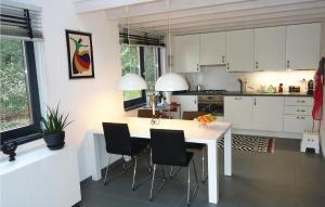 RekemVijverdorp - Type Waterlelie的厨房配有白色橱柜和桌椅
