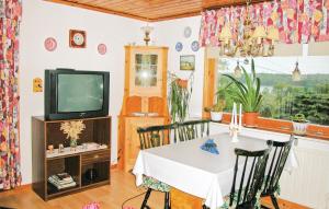 AspöCozy Home In Strngns With Kitchen的一间带桌子和电视的用餐室