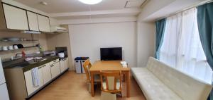 札幌札幌市中心部大通公園まで徒歩十分観光移動に便利なロケーションh203的小型公寓配有桌子、沙发和厨房