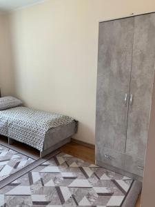 乔尔蓬阿塔Dastan的一间卧室配有床、橱柜和地毯