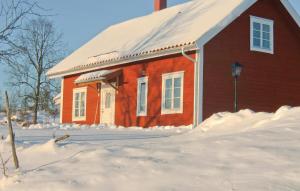 SkiröNice Home In Vetlanda With Wifi的前面有雪的红色房子