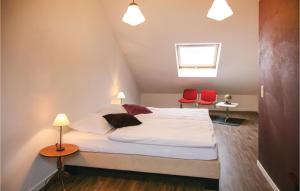HeppenbachSonnenhang的一间卧室配有一张床和两张红色椅子