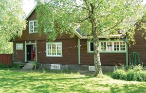 VisseltoftaCozy Home In Visseltofta With Kitchen的前面有一棵树的棕色房子