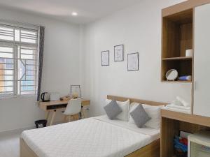 胡志明市Hello SaiGon Homestay的白色卧室配有床和书桌