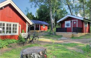 KvicksundAmazing Home In Kvicksund With Wifi的一辆红色的房子,前面停有一辆自行车