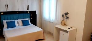 切萨雷奥港Villa Ginevra的一间卧室配有一张带蓝色床头板的床和一张桌子