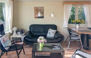 曲马勒姆Beautiful Home In Tzummarum With 2 Bedrooms, Wifi And Outdoor Swimming Pool的客厅配有黑色真皮座椅和桌子