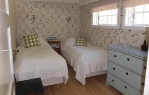 松德比Awesome home in Strngns with 2 Bedrooms and WiFi的一间卧室设有两张床、一个梳妆台和两个窗户。