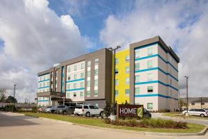 巴吞鲁日Home2 Suites By Hilton Baton Rouge Citiplace的大型公寓大楼,停车场有车辆停放