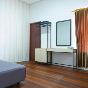 JetisDjuragan Kamar Ayem的一间卧室配有床、镜子和梳妆台