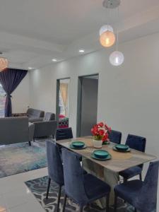 伯恩仓Ramadhina Eagle Eye View Home2stay Emerald Avenue的一间带桌子和蓝色椅子的用餐室