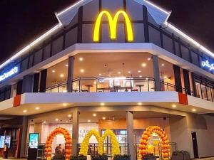 伯恩仓Ramadhina Eagle Eye View Home2stay Emerald Avenue的一座带mcdonalds餐厅(晚上)的mcdonalds建筑