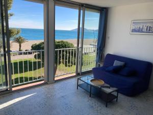滨海阿热莱斯Appartement vue sur mer的客厅配有蓝色沙发,享有海景