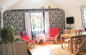 格内斯塔Lovely Home In Gnesta With Wifi的一间用餐室,配有红色的椅子和桌子