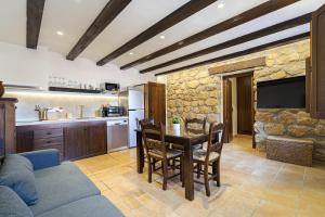 布龙查莱斯Casa Rural La Sierra的厨房以及带桌子和电视的客厅。