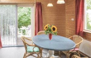 WijdenesHet Appelhuisje的一张带椅子的蓝色桌子和一个带向日葵的花瓶