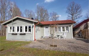 永比Amazing home in Ljungby with 3 Bedrooms and WiFi的白色的小房子,配有桌子和椅子