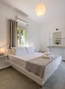 阿波罗尼亚Pente Elies Milos的白色卧室配有一张大床和两条毛巾