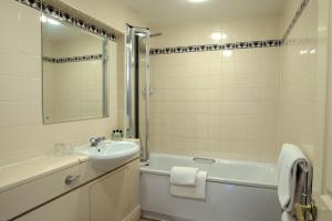 泰晤士河畔里士满纽约玫瑰宾馆的浴室配有盥洗盆、浴缸、卫生间和镜子