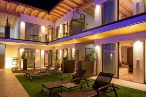 托里德尔贝纳科Relais Limonaia - Suites & Garden SPA的一座在庭院里晚上配有桌椅的建筑