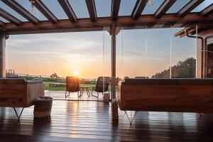 韦加港Hotel Rural La Sobreisla的甲板上透过窗户可欣赏到日落美景