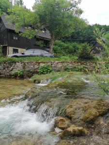 普利特维采湖San Korana的房屋前有瀑布的河流