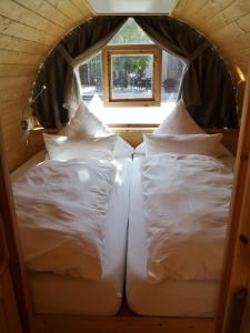 福尔卡赫Übernachten im Weinfass的小型客房设有2张白色的床和窗户。