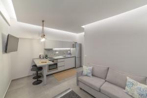 尼亚·蒙达尼亚Althea Suites by RentalsPro Services - Nea Moudania Halkidiki的带沙发的客厅和厨房