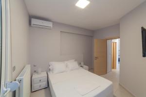 尼亚·蒙达尼亚Althea Suites by RentalsPro Services - Nea Moudania Halkidiki的白色的卧室设有床和窗户