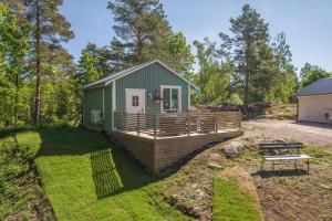 ÖdeshögCozy holiday house close to nature in Ödeshög, Gränna的一座绿色的小房子,在院子里有甲板