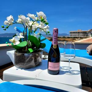 马略卡岛帕尔马Villa Mar Felostal的一瓶酒,放在桌子上,放着花瓶
