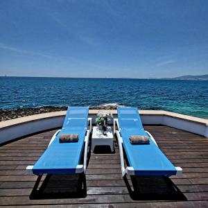马略卡岛帕尔马Villa Mar Felostal的靠近水面的码头上几张蓝色长椅
