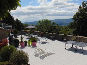 GluirasMaison d'Hotes Les Palmiers的庭院配有桌椅,背景为山脉