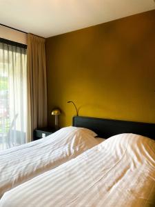 吉耶敦't兹瓦尼密尔酒店的卧室配有白色床和黄色墙