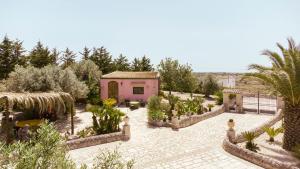 拉古萨Villa Vi的一座花园,里面种有粉红色的房子和一些植物