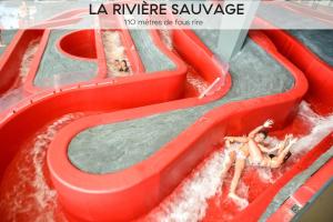 谷雪维尔Ecrin Blanc Resort Courchevel - Aquapark的水中两人的水滑梯