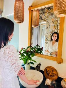 Song CauQue Toi Village Resort Phu Yen的站在镜子前的女人