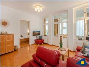 赛巴特班森Ostseevilla Whg 02的客厅配有红色椅子和红色沙发