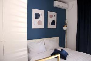 科托尔马尔科维奇公寓酒店的一间卧室设有蓝色的墙壁和一张带枕头的床。