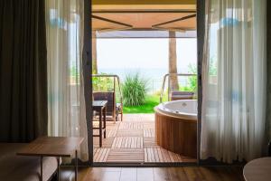 锡德Melas Resort Hotel的带浴缸和天井的客房