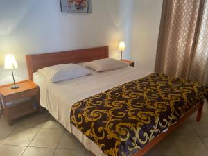 帕科坦Apartments Iva的一间卧室配有一张黄色和黑色毯子的床