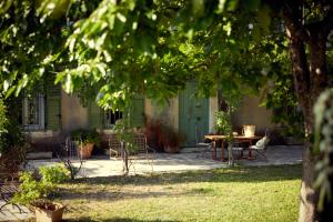 圣雷米普罗旺斯Hotel Moulin d'Aure的一个带桌椅的庭院和一扇绿门
