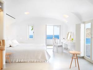 萨鲁Mykonos Blu, Grecotel Boutique Resort的白色卧室配有床和书桌