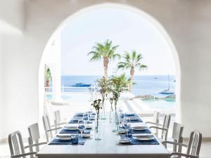 萨鲁Mykonos Blu, Grecotel Boutique Resort的一张长桌,享有海景