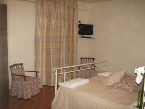 Colleretto GiacosaB&B Ristorante del Monte的一间卧室配有一张床、两把椅子和电视